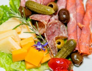 Simply Thyme charcuterie board - sliced meats, cheeses, olives, gherkins.