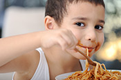 hungry kid eating spaghetti